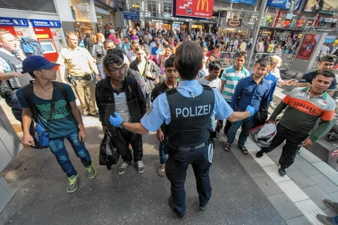 Cảnh sát hướng dẫn người tị nạn làm thủ tục đăng ký tại ga tàu điện ở Munich, Đức. (Ảnh: EPA)