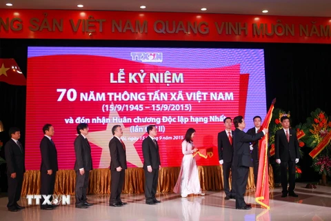 Thủ tướng Nguyễn Tấn Dũng gắn Huân chương Độc lập hạng Nhất lên Cờ truyền thống của Thông tấn xã Việt Nam. (Ảnh: TTXVN)