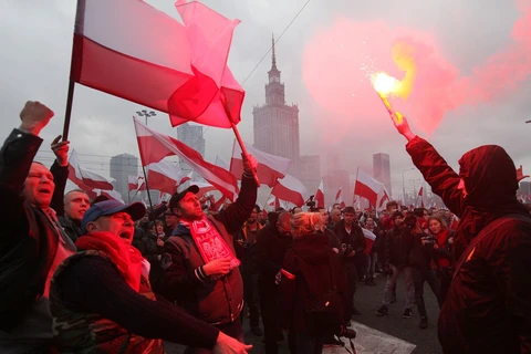 Người biểu tình cầm cờ Ba Lan trong cuộc tuần hành. (Ảnh: AP)