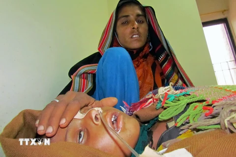 Một bà mẹ Pakistan chăm sóc con mắc bệnh sởi tại bệnh viện ở thành phố Sukkur, tỉnh Sindh. (Ảnh: AFP/TTXVN)