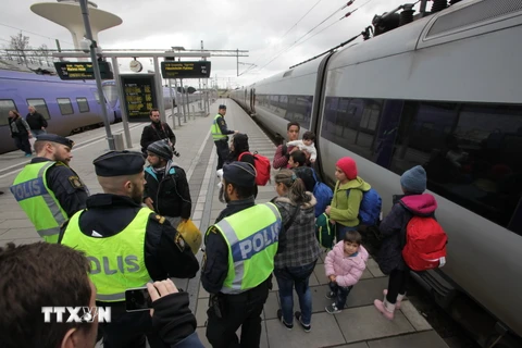 Cảnh sát kiểm tra nhóm người nhập cư tại sân ga ở Malmo. (Ảnh: AFP/TTXVN)