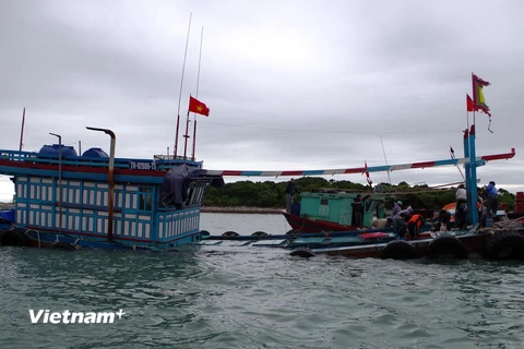 Đưa tàu bị nạn vào bờ. (Ảnh: Nguyễn Hoàng/Vietnam+) 