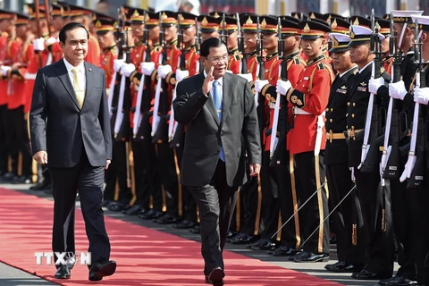 Thủ tướng Thái Lan Prayut Chan-O-Cha (trái) và ​người đồng cấp Campuchia Hun Sen duyệt đội danh dự. (Ảnh: AFP/TTXVN)