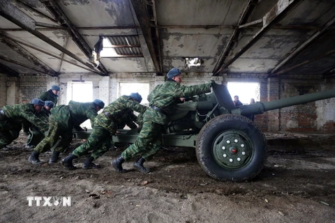Lực lượng ly khai chuyển súng chống tăng MT-12 Rapira vào nhà kho ở Zelene, vùng Donetsk ngày 28/10. (Ảnh: AFP/TTXVN)
