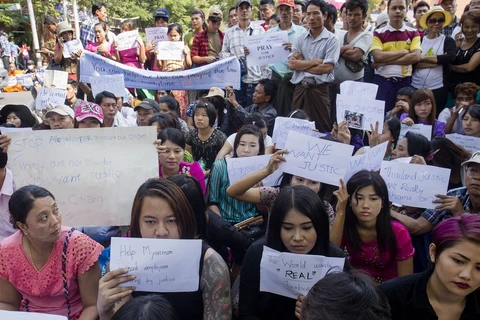 Người biểu tình Myanmar ngồi bên ngoài Đại sứ quán Thái Lan tại Yangon hôm 26/12. (Ảnh: AFP)