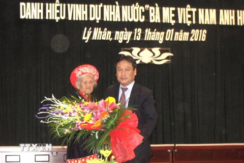 Phó Chủ tịch UBND tỉnh Hà Nam Vũ Đại Thắng tặng hoa Bà mẹ Việt Nam Anh hùng Trần Thị Tuyết. (Ảnh: TTXVN)