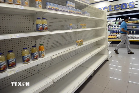Các giá hàng trống rỗng vì thiếu hàng hóa tại một siêu thị ở Caracas. (Ảnh: AFP/TTXVN)