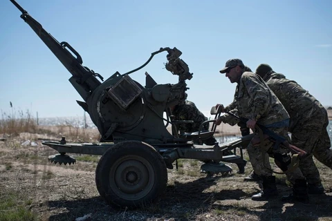 Các binh sỹ chính phủ Ukraine triển khai vũ khí tại bãi biển Azov, miền Đông Ukraine. (Ảnh: AP)