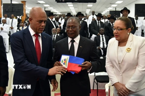 Cựu Tổng thống Haiti Michel Martelly (trái) chuyển giao biểu tượng quyền lực cho ông Jocelerme Privert. (Ảnh: AFP/TTXVN)