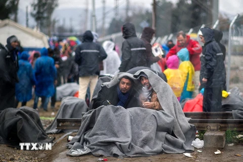 Người tị nạn chờ đợi qua khu vực biên giới Hy Lạp- Macedonia ngày 24/2. (Ảnh: AFP/TTXVN)