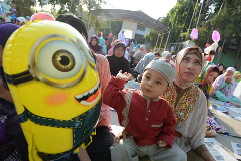 Một bà mẹ Indonesia và cậu con trai tham gia một buổi lễ cầu nguyện ở Jakarta. (Ảnh: AFP)