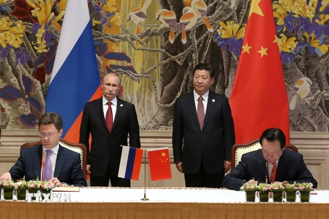 Đại diện tập đoàn Gazprom và đối tác Trung Quốc ký kết thỏa thuận hợp tác dưới sự chứng kiến của Tổng thống Nga Putin và Chủ tịch Trung Quốc Tập Cận Bình. (Nguồn: AFP/TTXVN)