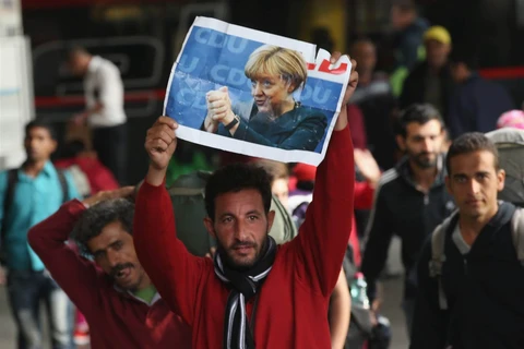 Một người nhập cư cầm bức ảnh của Thủ tướng Angela Merkel khi đến Đức. (Nguồn: Getty Images)