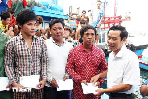 Đại diện Liên đoàn Lao động tỉnh Khánh Hòa thăm hỏi, hỗ trợ ngư dân gặp nạn. (Ảnh: Nguyên Lý/TTXVN)