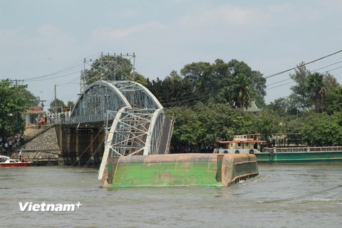 Chiếc sà lan bị chết máy đã đâm sập 2 nhịp giữa Cầu Ghềnh bắc qua sông Đồng Nai. (Ảnh: Sỹ Tuyên/Vietnam+)