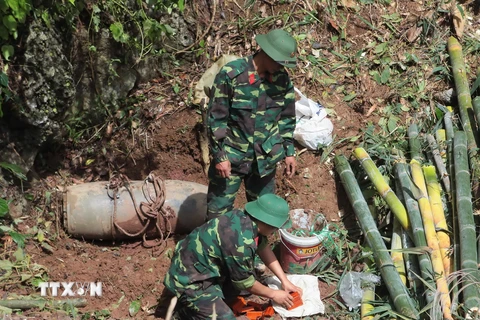 Lực lượng công binh lắp đặt thuốc nổ để hủy nổ quả bom. (Ảnh: Lê Hữu Quyết/TTXVN)