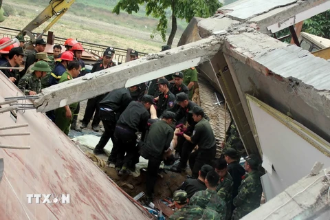 Lực lượng cứu hộ tìm kiếm được một nạn nhân trong đống đổ nát. (Ảnh: Quốc Đạt/TTXVN)
