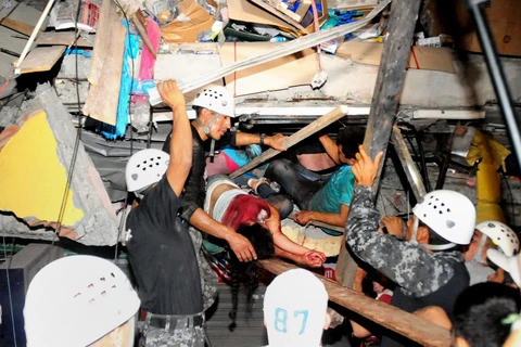 Nhân viên cứu hộ đưa những người bị mắc kẹt ra khỏi đống đổ nát sau trận động đất. (Nguồn: AFP)