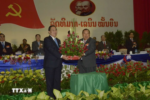 Nguyên Tổng Bí thư Chummaly Sayasone (trái) tặng hoa cho ông Bounnhang Volachith. (Ảnh: Phạm Kiên/TTXVN)