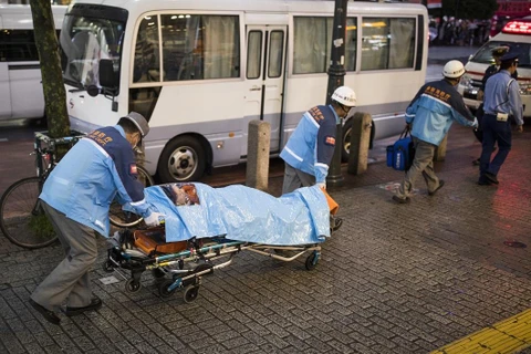 Nhân viên y tế chuyển bệnh nhân bị nghi mắc COVID-19 tại quận Shibuya, Tokyo, Nhật Bản. (Ảnh: AFP/TTXVN)