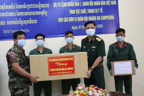 Thiếu tướng Nguyễn Trường Thắng, Phó Tư lệnh Quân khu 7 trao tặng vật tư y tế chống dịch COVID-19 cho Quân khu 4 Quân đội Hoàng gia Campuchia. (Ảnh: Lê Đức Hoảnh/TTXVN)