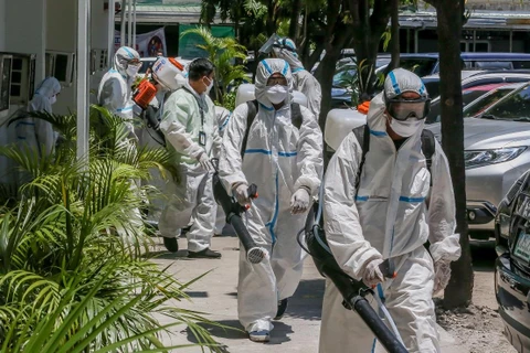 Nhân viên phun thuốc khử trùng nhằm ngăn chặn sự lây lan của dịch COVID-19 tại Manila, Philippines, ngày 7/4/2020. (Ảnh: THX/TTXVN)