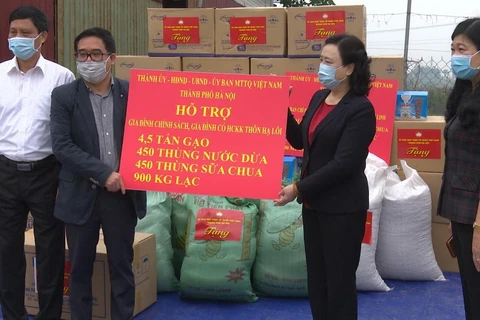 Lãnh đạo Thành ủy Hà Nội tặng quà cho huyện Mê Linh để phòng, chống dịch COVID-19. (Ảnh TTXVN phát)