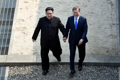 Tổng thống Moon Jae-in và nhà lãnh đạo Kim Jong-un nắm tay nhau tại làng đình chiến Panmunjom. (Nguồn: Reuters)
