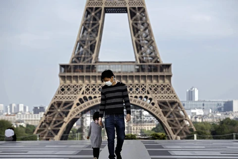 Trẻ em thăm Tháp Eiffel ở Paris, Pháp trong bối cảnh dịch COVID-19 bùng phát mạnh, ngày 20/4/2020. (Ảnh: AFP/TTXVN)