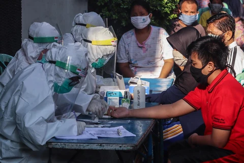Nhân viên y tế lấy máu xét nghiệm COVID-19 cho người dân tại Surabaya, Đông Java, Indonesia ngày 13/5/2020. (Ảnh: THX/TTXVN)