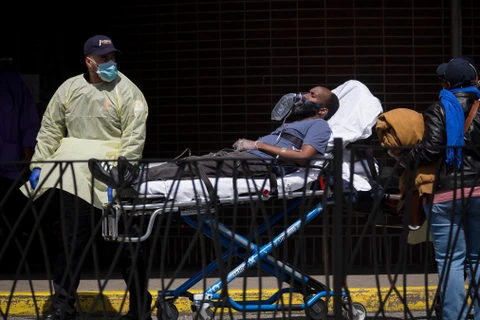 Nhân viên y tế chuyển bệnh nhân mắc COVID-19 vào một bệnh viện ở New York, Mỹ ngày 14/4/2020. (Ảnh: THX/TTXVN)