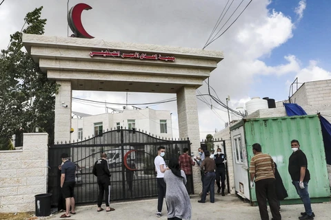 Người dân tập trung bên ngoài một bệnh viện ở thành phố Hebron, Bờ Tây để chờ xét nghiệm COVID-19 ngày 19/6/2020. (Ảnh: AFP/TTXVN)