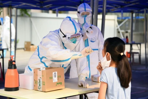 Nhân viên y tế lấy mẫu xét nghiệm COVID-19 cho người dân tại Bắc Kinh, Trung Quốc, ngày 23/6/2020. (Ảnh: THX/TTXVN)