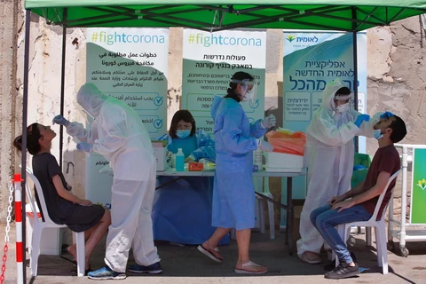 Nhân viên y tế lấy mẫu xét nghiệm COVID-19 tại Lod,miền trung Israel. (Ảnh: THX/TTXVN)