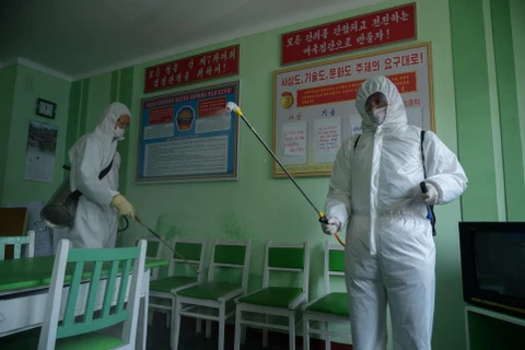 Nhân viên y tế phun thuốc khử trùng nhằm ngăn chặn sự lây lan của dịch COVID-19 tại Bình Nhưỡng, Triều Tiên. (Ảnh: AFP/TTXVN)