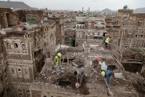 Các công nhân dọn dẹp một tòa nhà bị sụp đổ do mưa lớn ở thành phố cổ Sanaa, Yemen. (Nguồn: Reuters)
