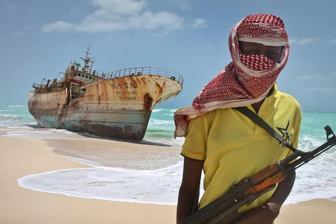 Cướp biển Somalia đứng cạnh một con tàu bị bắt. (Nguồn: AP)
