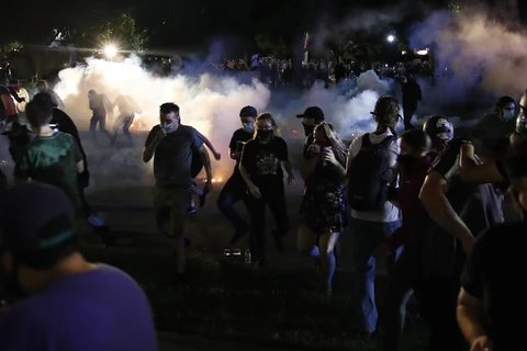 Người biểu tình xung đột với cảnh sát trong cuộc tuần hành phản đối vụ cảnh sát bắn người da màu tại Kenosha, bang Wisconsin (Mỹ) ngày 25/8/2020. (Ảnh: AFP/TTXVN)