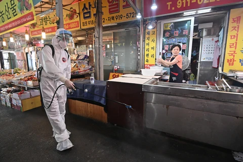 Phun thuốc khử trùng nhằm ngăn chặn sự lây lan của dịch COVID-19 tại một khu chợ ở Seoul, Hàn Quốc ngày 18/8/2020. (Ảnh: AFP/TTXVN)