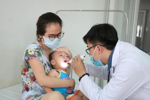 Khám cho bệnh nhi mắc bệnh tay-chân-miệng đang điều trị tại Bệnh viện đa khoa vùng Tây Nguyên. (Ảnh: Tuấn Anh/TTXVN)