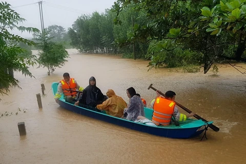 Di chuyển người dân ra khỏi khu vực ngập lũ tại huyện Cam Lộ, tỉnh Quảng Trị. (Ảnh: Thanh Thủy/TTXVN)