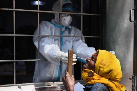 Nhân viên y tế lấy mẫu dịch COVID-19 cho người dân tại New Delhi, Ấn Độ, ngày 19/10/2020. (Ảnh: AFP/TTXVN)