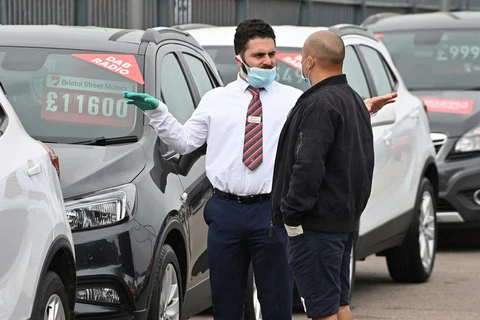 Nhân viên giới thiệu khách tới mua xe tại London, Anh. (Nguồn: AFP)