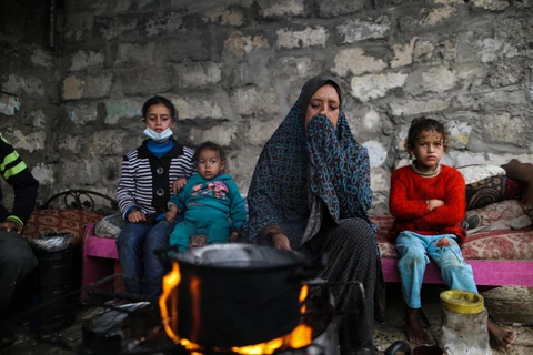 Người dân Palestine sưởi ấm tại trại tị nạn ở thành phố Khan Younis, Dải Gaza ngày 26/11/2020. (Ảnh: THX/TTXVN)