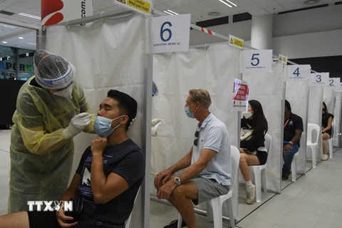 Nhân viên y tế lấy mẫu xét nghiệm COVID-19 cho người dân tại Singapore ngày 27/2/2021. (Ảnh: THX/TTXVN)