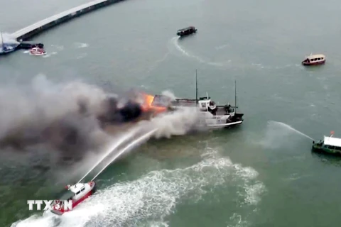 Lực lượng chức năng nỗ lực dập đám cháy tàu du lịch trên vịnh Hạ Long. (Ảnh: TTXVN phát)