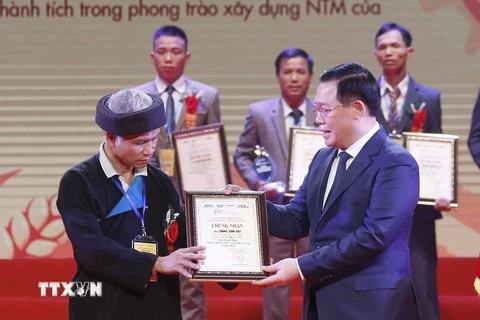 CChủ tịch Quốc hội Vương Đình Huệ trao tặng danh hiệu cho Nhóm các nông dân Việt Nam có thành tích xuất sắc trong lĩnh vực Phát minh, chuyển đổi số, xây dựng Nông thôn mới và bảo vệ ninh Tổ quốc. (Ảnh: Doãn Tấn/TTXVN)