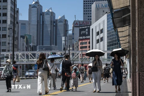 Người dân di chuyển dưới trời nắng nóng tại Tokyo, Nhật Bản ngày 30/7/2023. (Ảnh: AFP/TTXVN)