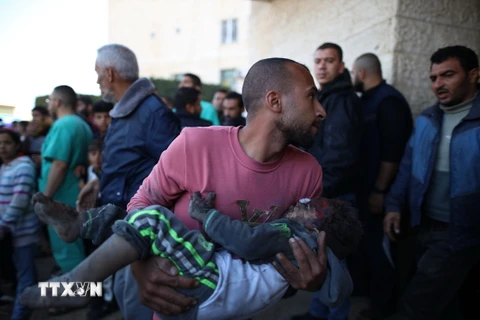 Chuyển một em nhỏ bị thương trong cuộc không kích của Israel vào bệnh viện ở thành phố Deir el-Balah, Dải Gaza, ngày 11/12/2023. (Ảnh: THX/TTXVN)