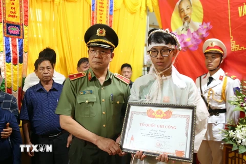 Trao Bằng Tổ quốc ghi công cho gia đình Thiếu tá Hoàng Trung, cán bộ Công an xã Ea Ktur, huyện Cư Kuin. (Ảnh: Quang Thái/TTXVN)